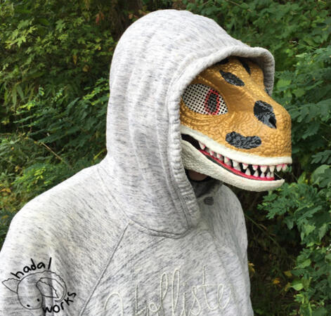 A plastic dinosaur mask painted to look like a leopard gecko.